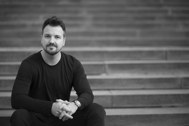 Mark Asquith black and white profile picture sitting on steps