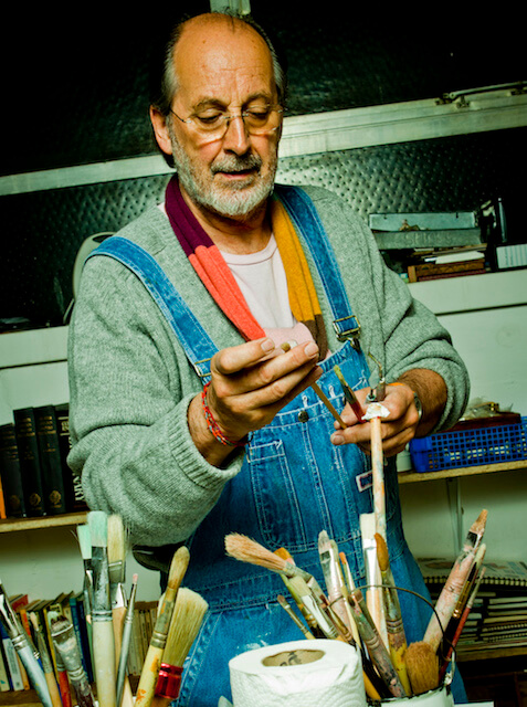 Painter John Link painting in his studio selecting a brush